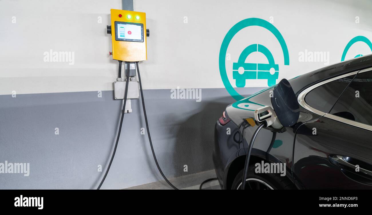 Le auto elettriche vengono addebitate dalla stazione di ricarica nel parcheggio interno del centro commerciale Foto Stock