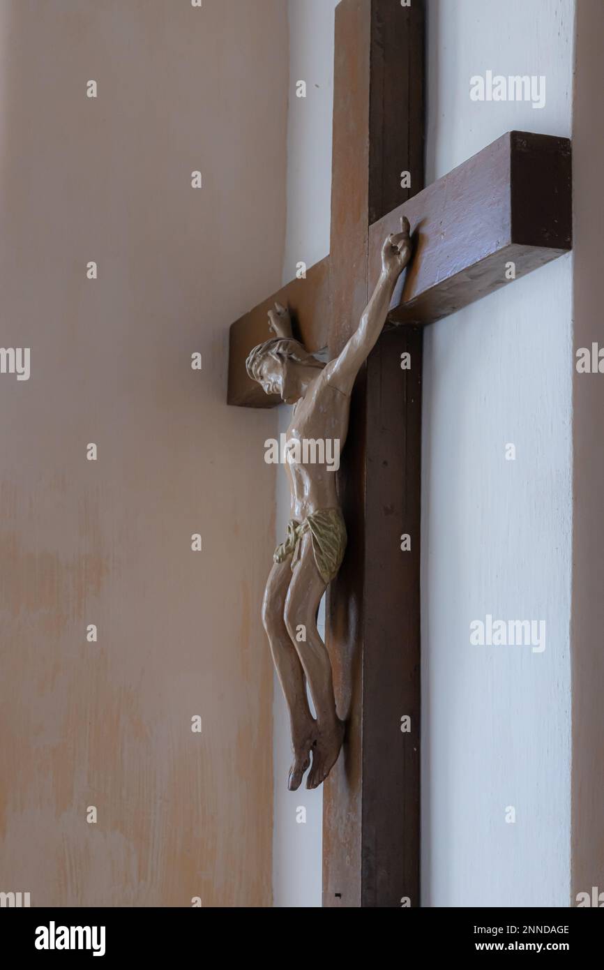 Gesù cristo sulla croce con sfondo muro nella chiesa cattolica. Foto Stock