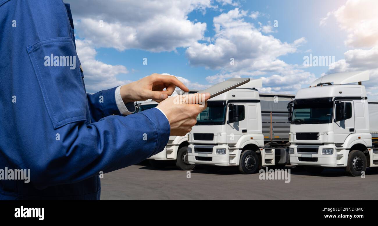 Manager con un tablet digitale accanto ai veicoli. Gestione della flotta Foto Stock