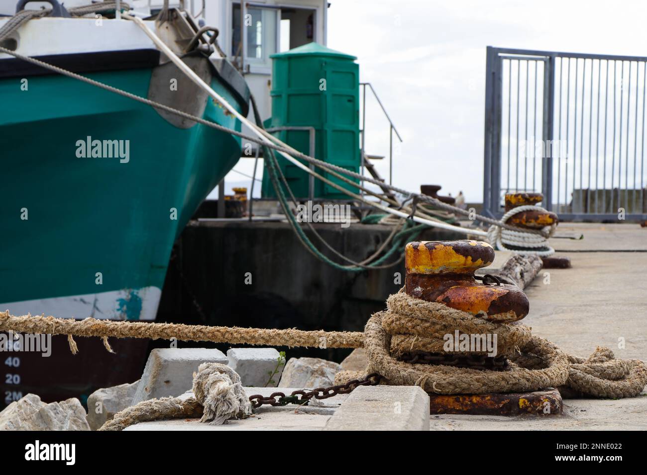 Metallo Bollard su Harbor Quay con barche legate Foto Stock