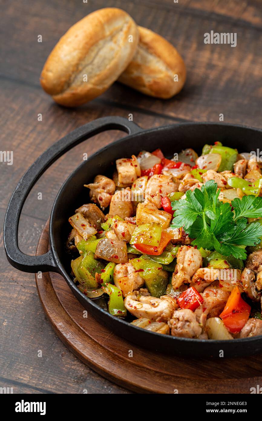 Il pollo saltato con pepe in una padella di ghisa Foto Stock