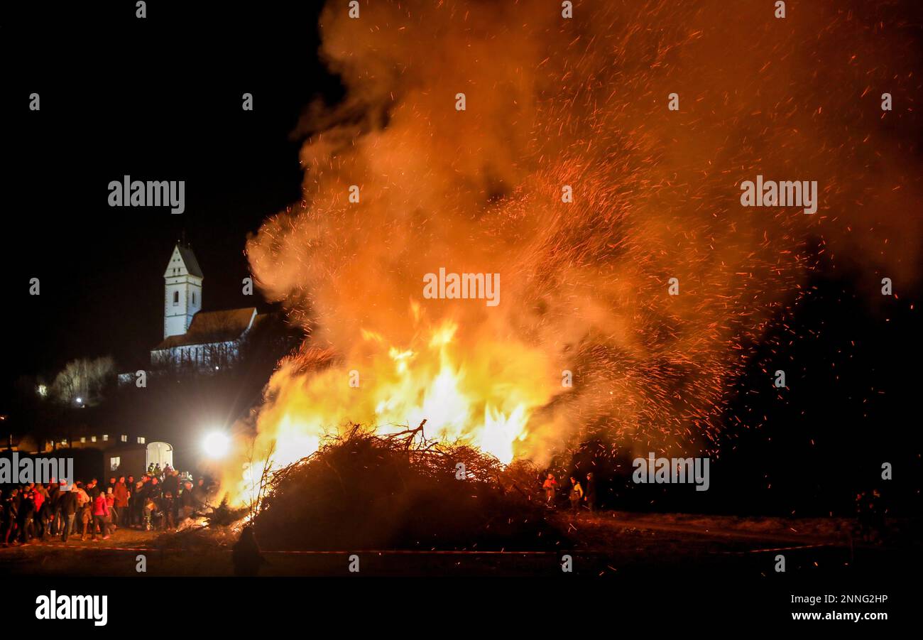 Uttenweiler, Germania. 25th Feb, 2023. Sotto la chiesa di pellegrinaggio di San Giovanni Battista sulla montagna 'Bussen' di Offingen, una scintilla brucia. La vecchia usanza è destinata a guidare via l'inverno. Credit: Thomas Warnack/dpa/Alamy Live News Foto Stock