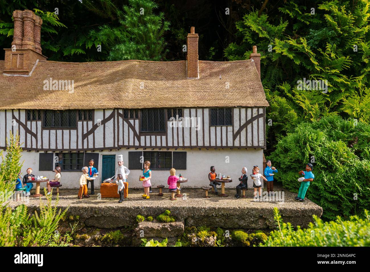 06.08.2021 Torquay, Regno Unito. Babbacombe in miniatura Model Village. Scena con persone che cenano all'aperto. Foto Stock