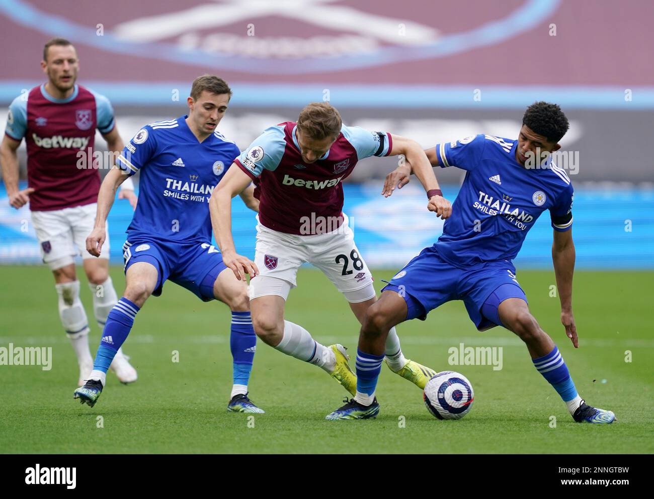 West Ham United's Tomas Soucek, centre, duels for the ball with Leicester City's Wesley Fofana, right, during the English Premier League soccer match between West Ham United and Leicester City at the London Stadium in London, Sunday, April 11, 2021. (John Walton/Pool via AP) Foto Stock