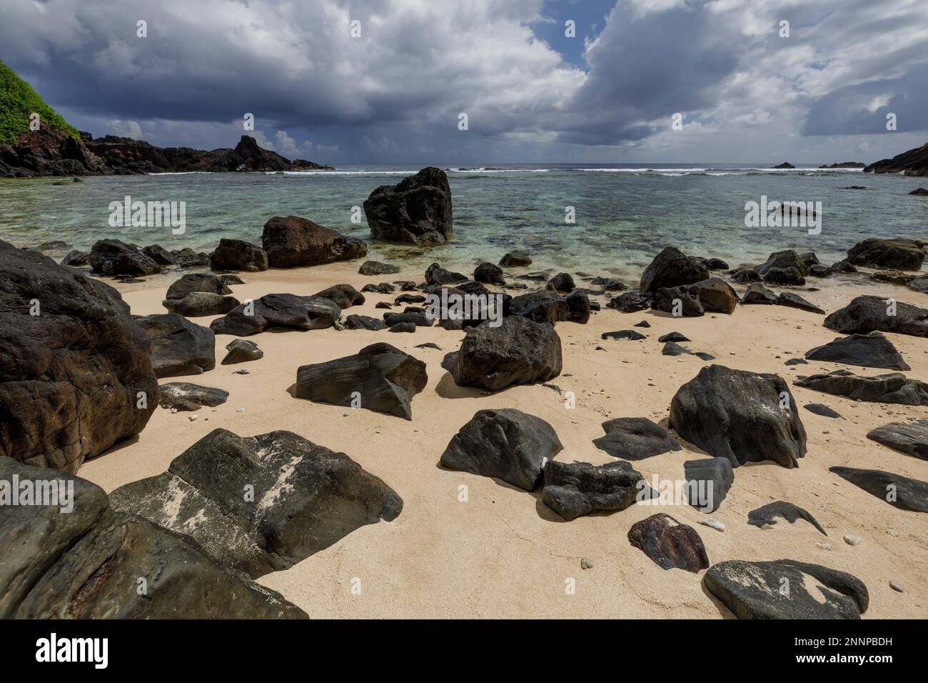 Rocce nere e spiagge di sabbia bianca lungo la costa del villaggio di Amanave, Tutuila, Samoa Americane Foto Stock