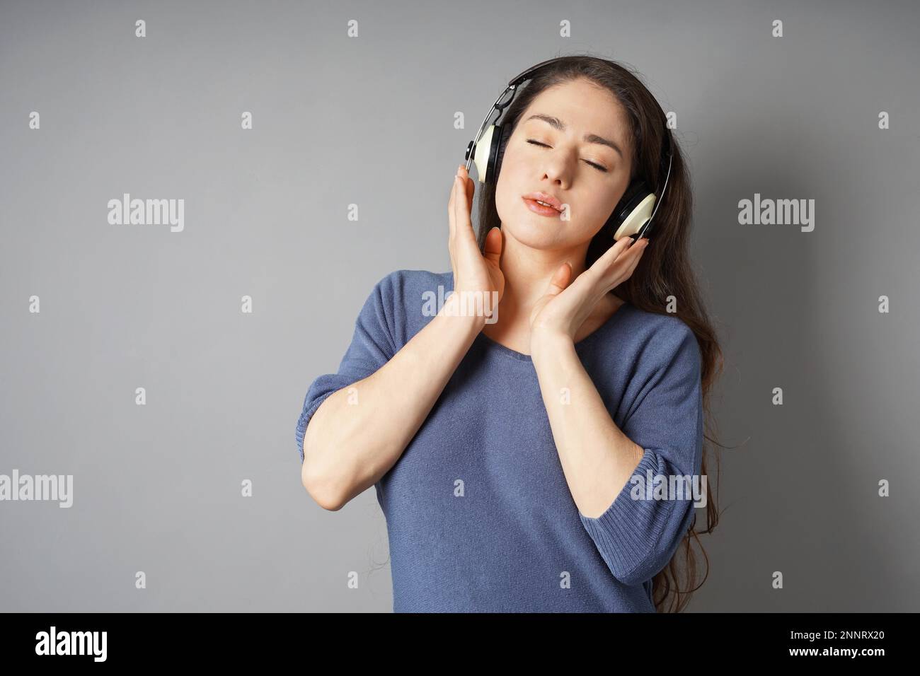 Giovane donna ascolto di musica con cuffie wireless - ragazza di ascoltare con gli occhi chiusi Foto Stock