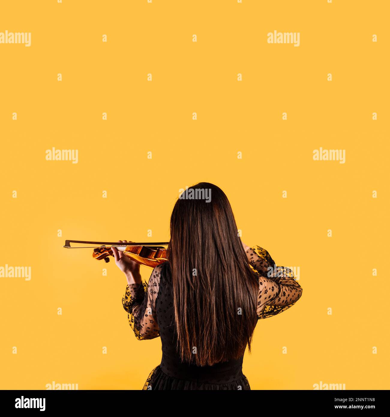 ragazza che mostra la schiena suonando violino. Foto ad alta risoluzione Foto Stock