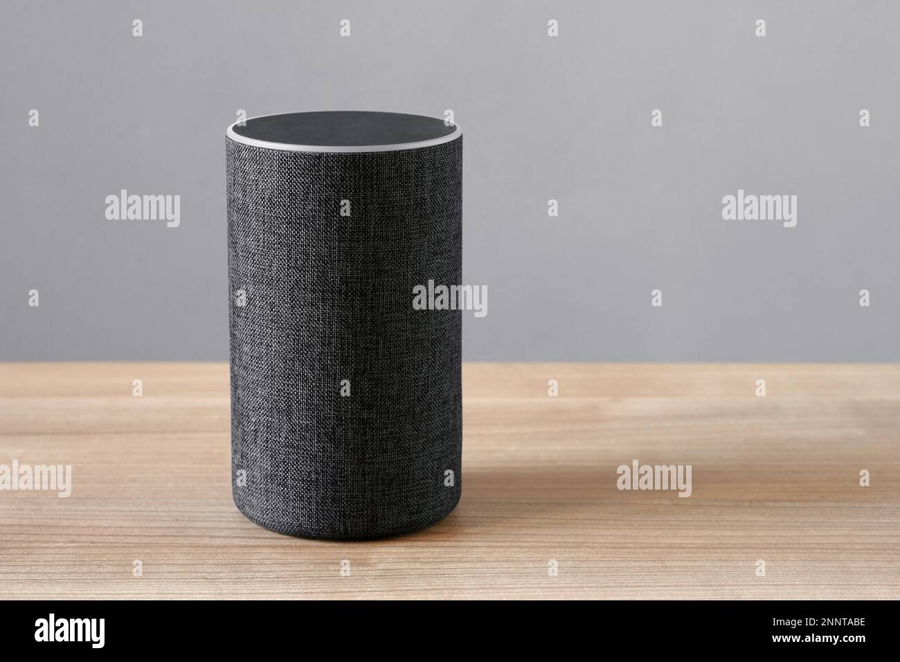 Smart speaker assistente virtuale per smart home su banco - Sfondo grigio con spazio di copia Foto Stock