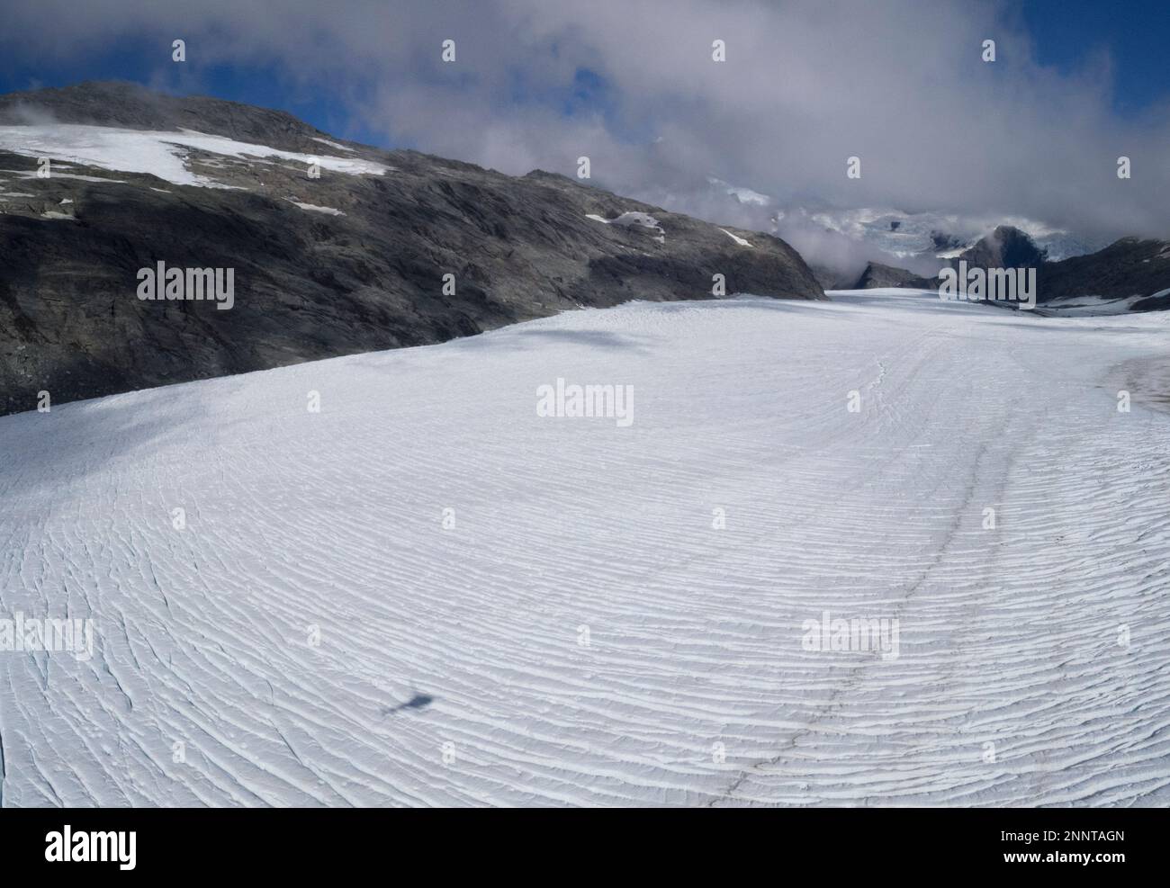 Ombra di elicottero che sorvola il ghiacciaio, Mount aspiranti Parco Nazionale, West Coast, South Island, Nuova Zelanda Foto Stock