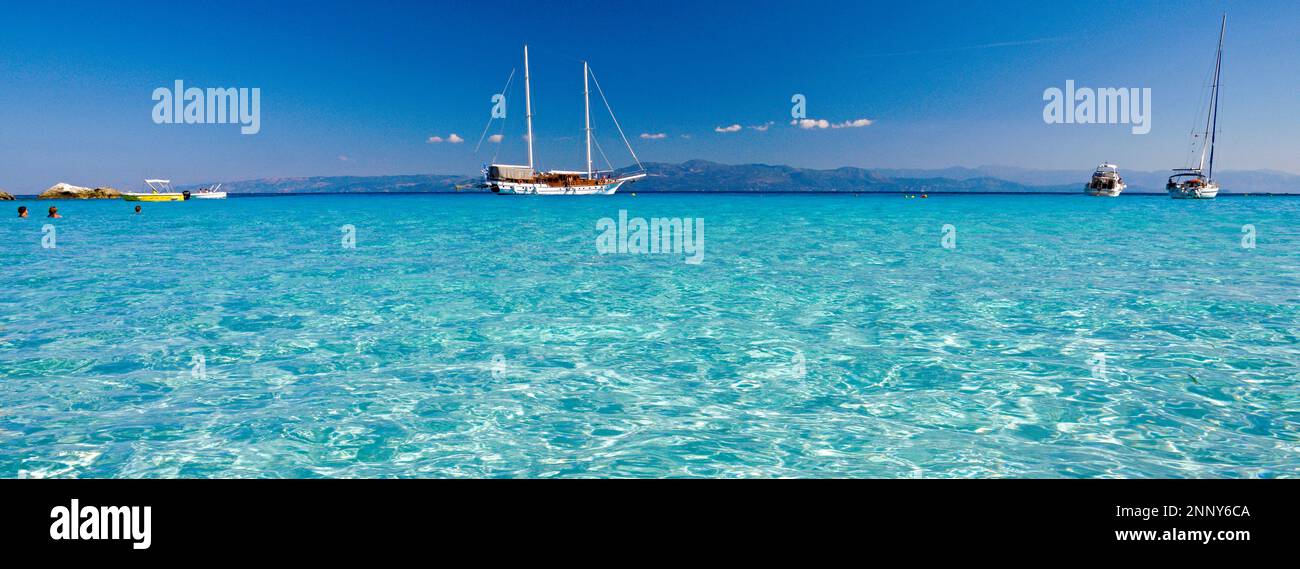 Acque blu e barche a vela a Lakka Bay, Paxos, Isole IONIE, Grecia Foto Stock
