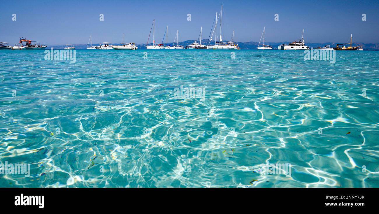 Barche e acque turchesi a Lakka Bay, Paxos, Isole IONIE, Grecia Foto Stock