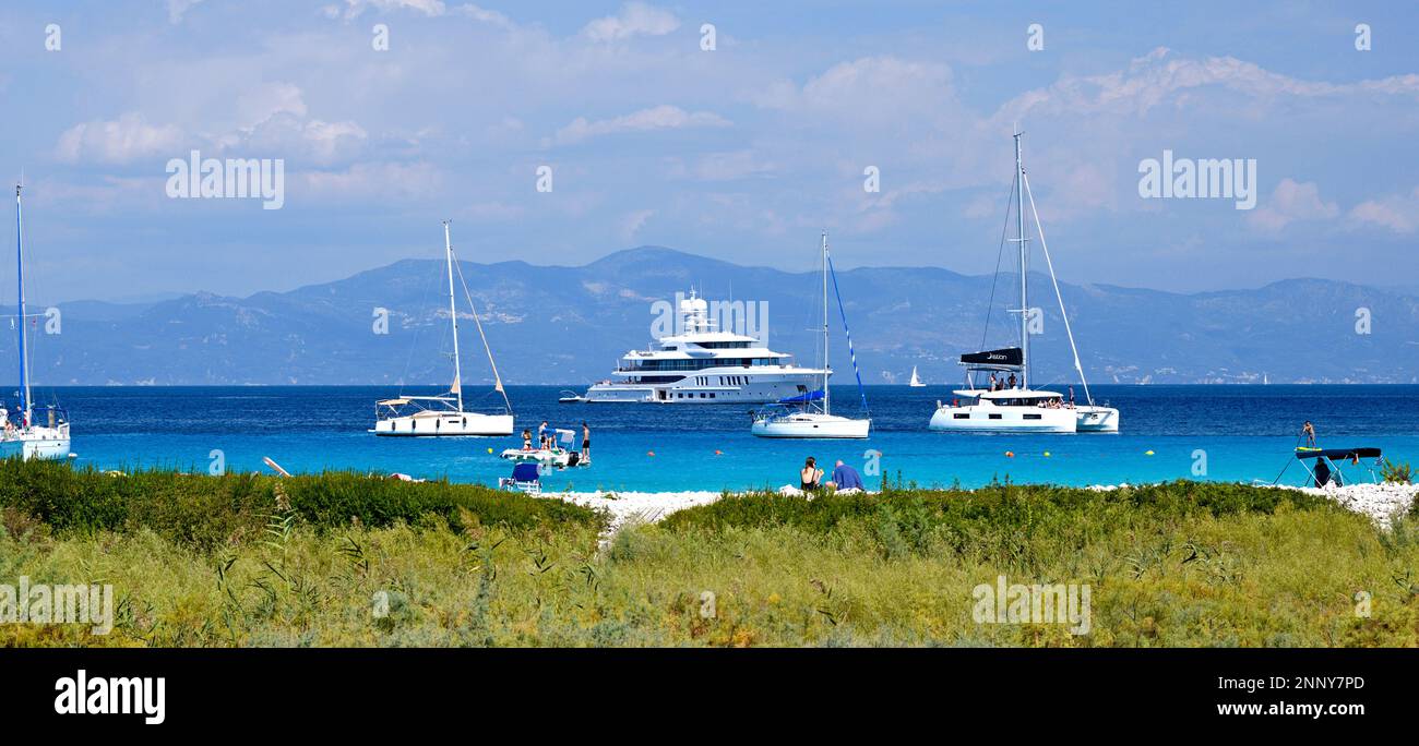 Turisti in spiaggia e barche a vela a Lakka Bay, Paxos, Isole IONIE, Grecia Foto Stock