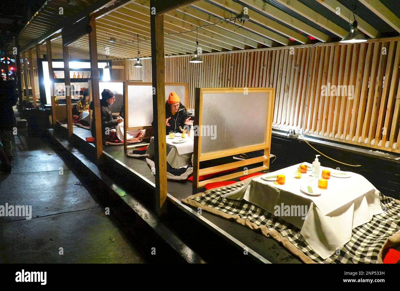 A picture taken on Dec. 18, 2020 shows outdoor kotasu tables at a Japanese restaurant Dr Clark in New York. The restaurant owner Yudai Kanayama opened the restaurant in March, 2020 and struggling to fight against the situation of novel coronavirus COVID-19 infestion. Kotatsu is used at Japanese home and it has a heater inside. ( The Yomiuri Shimbun via AP Images ) Foto Stock