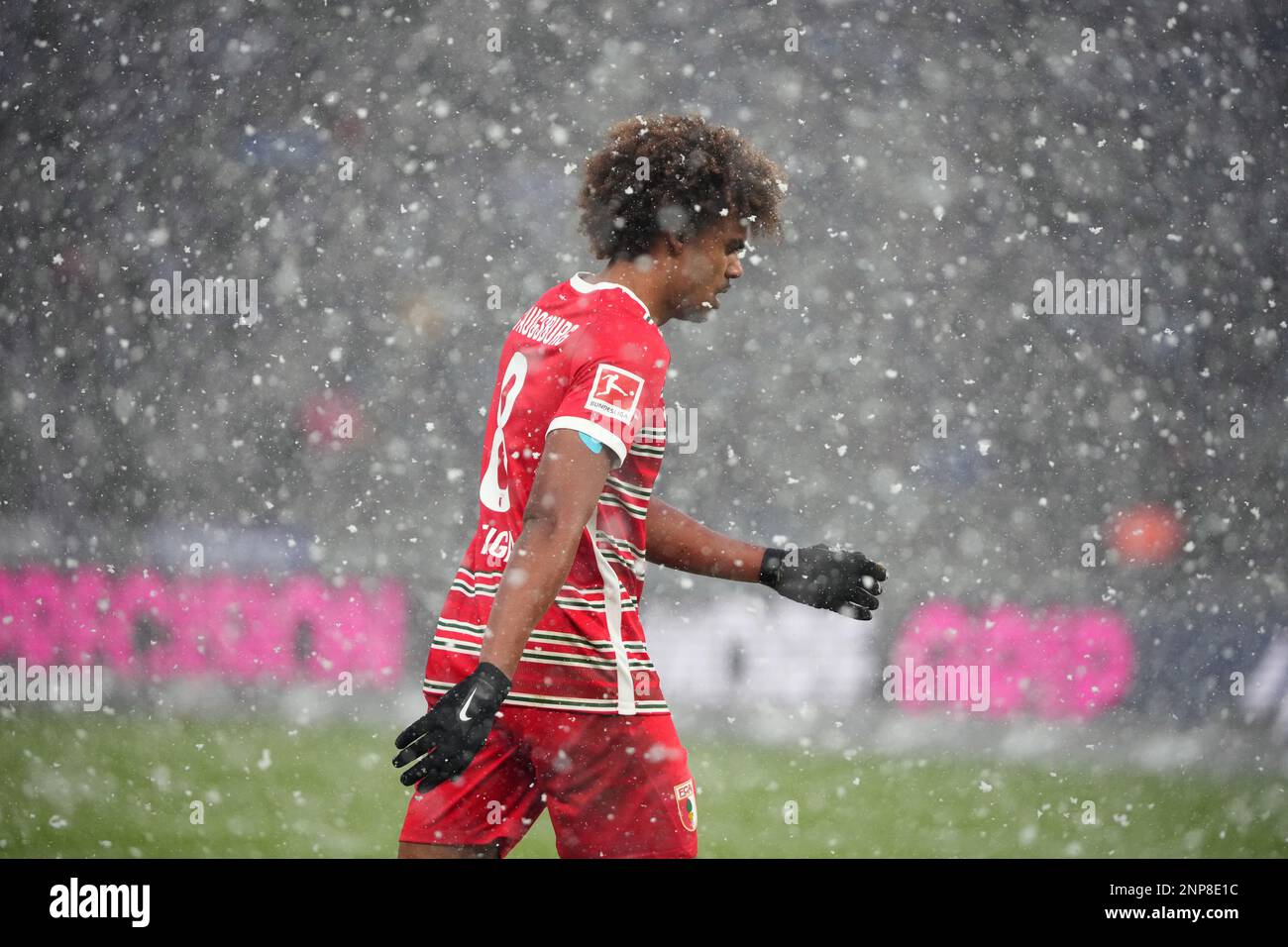 Berlino, Germania. 25th Feb, 2023. Calcio: Bundesliga, Hertha BSC - FC Augsburg, 22nd° giorno, Olympiastadion, Amaral Borduchi Lago di Augusta cammina sul campo nella neve guida. Credit: Soeren Stache/dpa - NOTA IMPORTANTE: In conformità ai requisiti della DFL Deutsche Fußball Liga e del DFB Deutscher Fußball-Bund, è vietato utilizzare o utilizzare fotografie scattate nello stadio e/o della partita sotto forma di sequenze di immagini e/o serie di foto simili a video./dpa/Alamy Live News Foto Stock