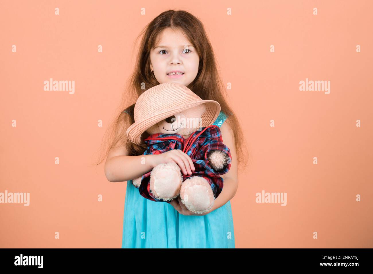 Il più bello di sempre. Accessori per tender. La bambina tiene peluche peluche dell'orso peloso cappello di paglia del giocattolo. Innamorato dell'orso peloso carino. Buona infanzia. Bambina di capretto Foto Stock