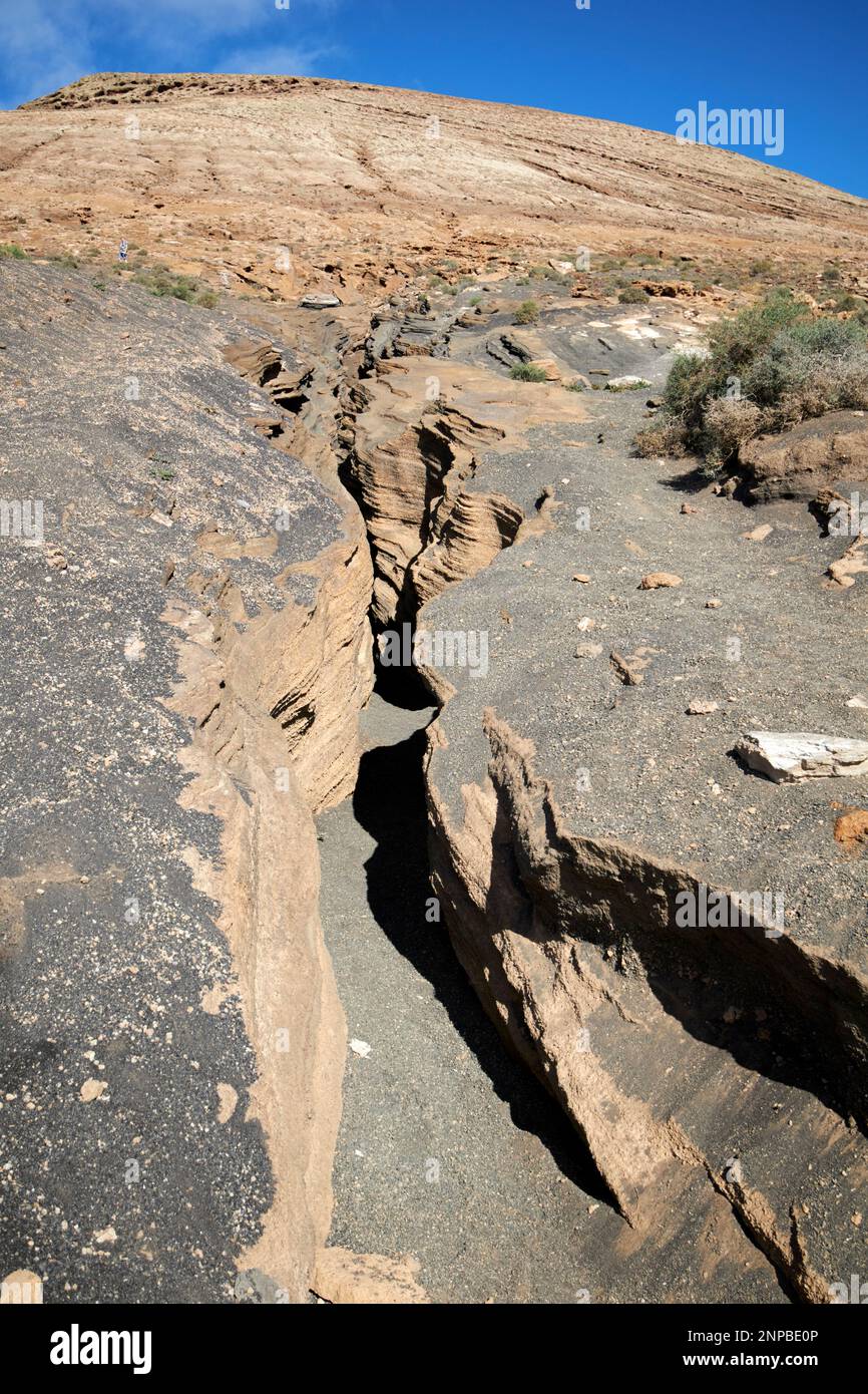 Ladera del volcan Las Grietas Lanzarote, Isole Canarie, Spagna formazioni rocciose vulcaniche causate dall'erosione con vista del montana blanca Foto Stock