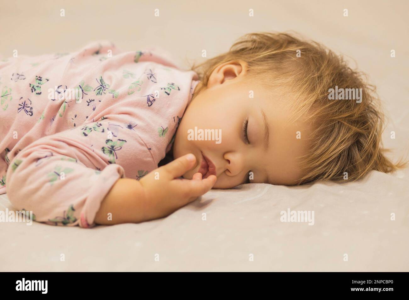 Ragazza cute del bambino leale-haired che dorme sulla pancia Foto Stock