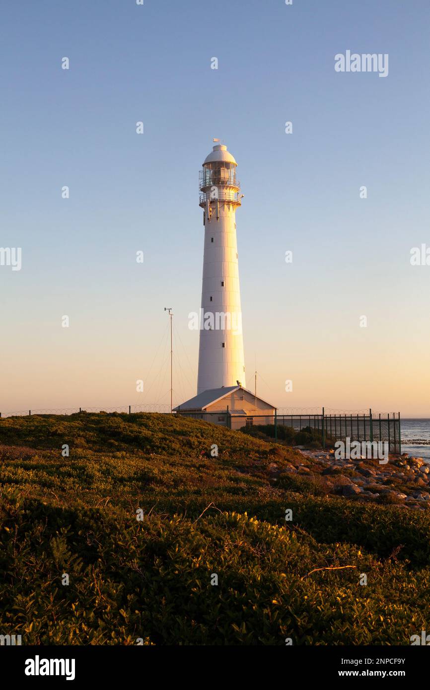 Faro di Slangkop, Kommetjie, Capo Occidentale, Sud Africa al tramonto dal lungomare costiero. Torre in ghisa commissionata nel 1914 Foto Stock