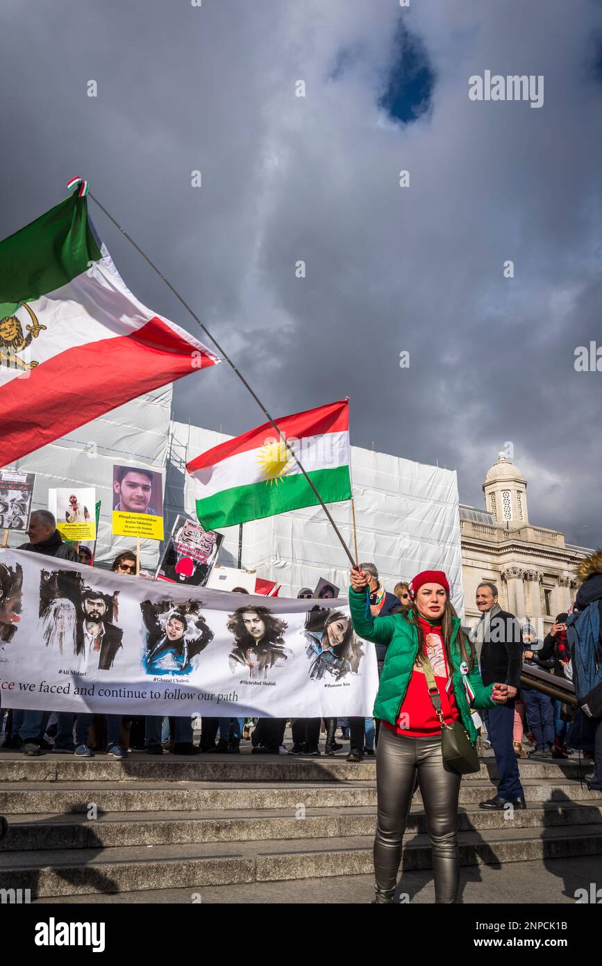 Donna che rinuncia alla bandiera iraniana a Trafalgar Square, protesta pro-democrazia iraniana contro il governo islamico autocratico dell'Iran, nel centro di Londra, Foto Stock