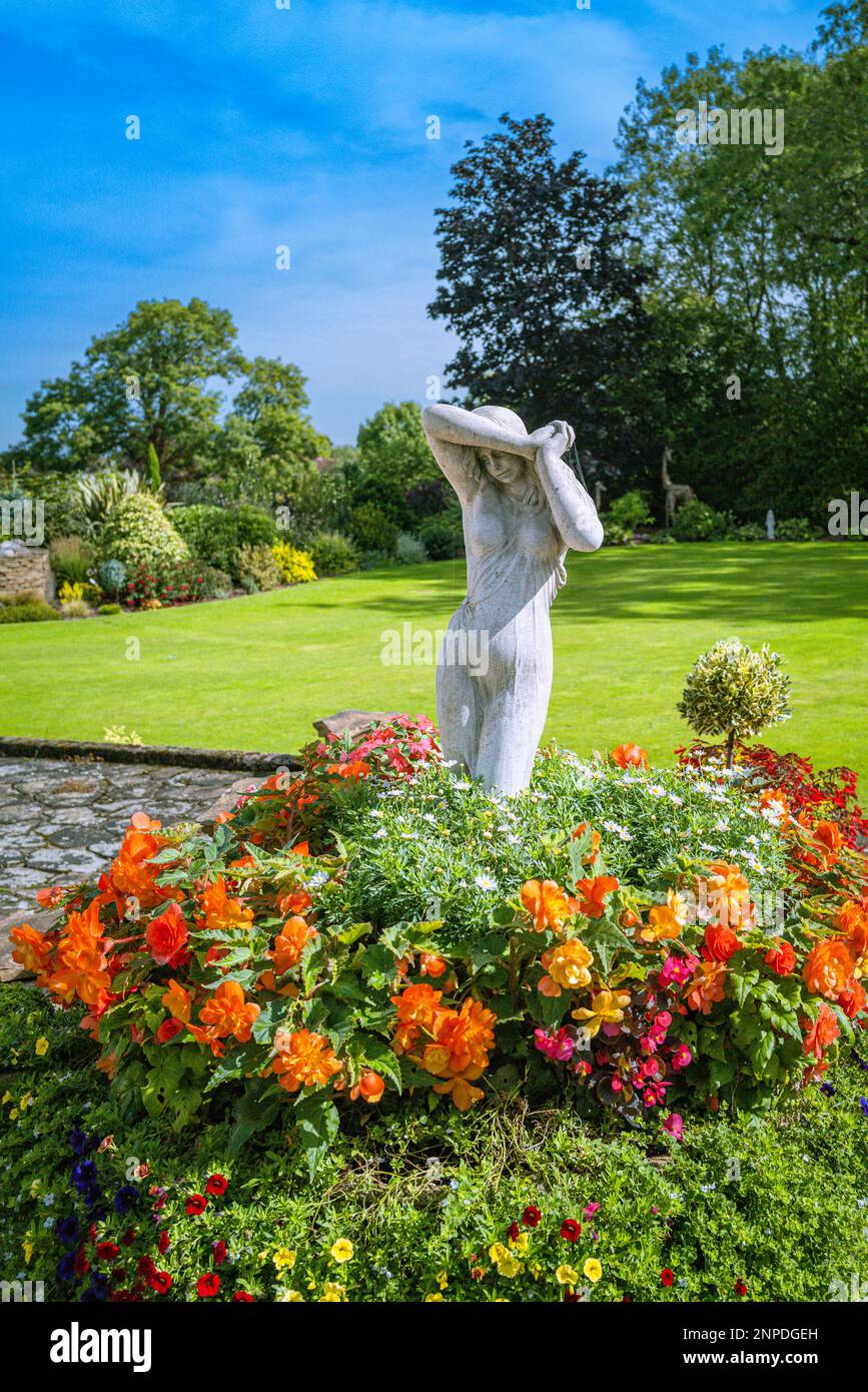 Una statua femminile è un elemento in un grande giardino. Foto Stock