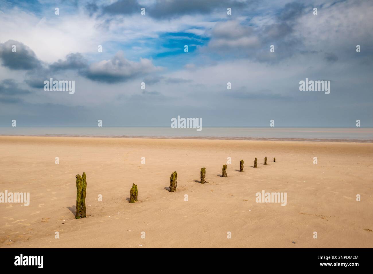 Una spiaggia abbandonata di Norfolk con i resti di un frangiflutti. Foto Stock