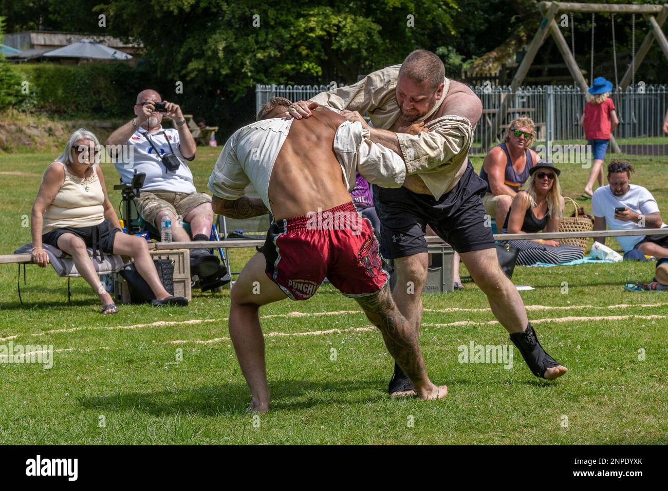 Concorrenti nel primo round del Mens Open nel Grand Cornish Wrestling Tournament sul pittoresco villaggio verde di St Mawgan a Pydar in Cornovaglia in Inghilterra nel Regno Unito. Foto Stock