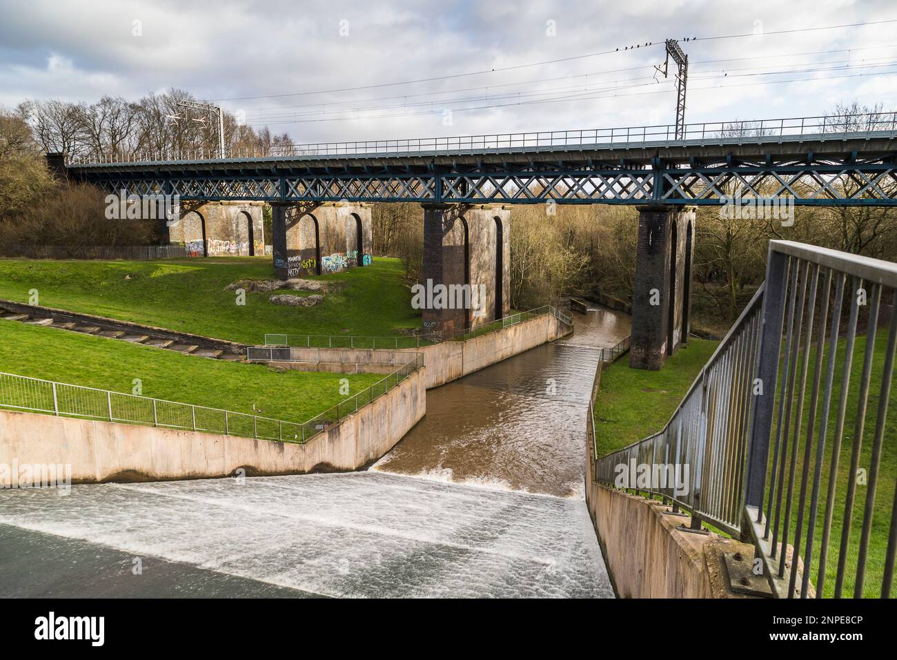 Acqua che scorre lungo la diga di Carr Mill verso il Sankey Valley Park alla periferia di St Helens a Merseyside. Foto Stock