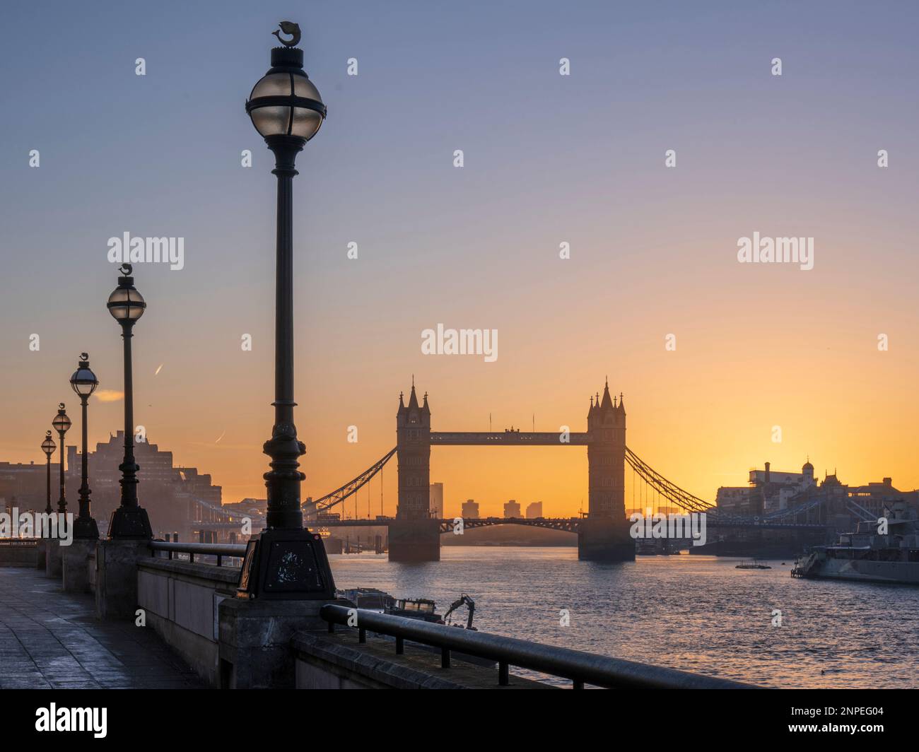 Tower Bridge incorniciato da lampioni all'alba. Foto Stock