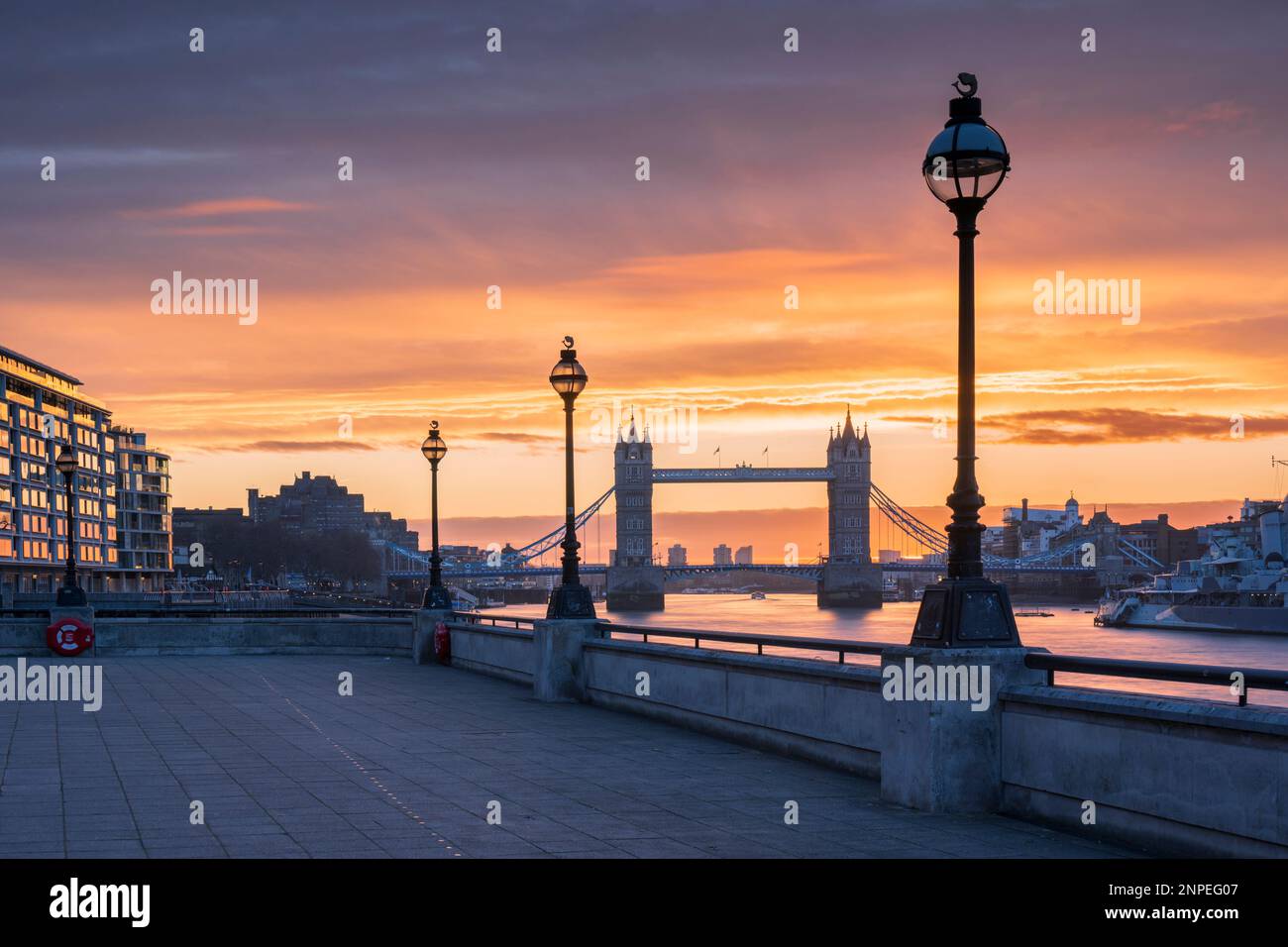 Tower Bridge incorniciato da lampioni all'alba. Foto Stock