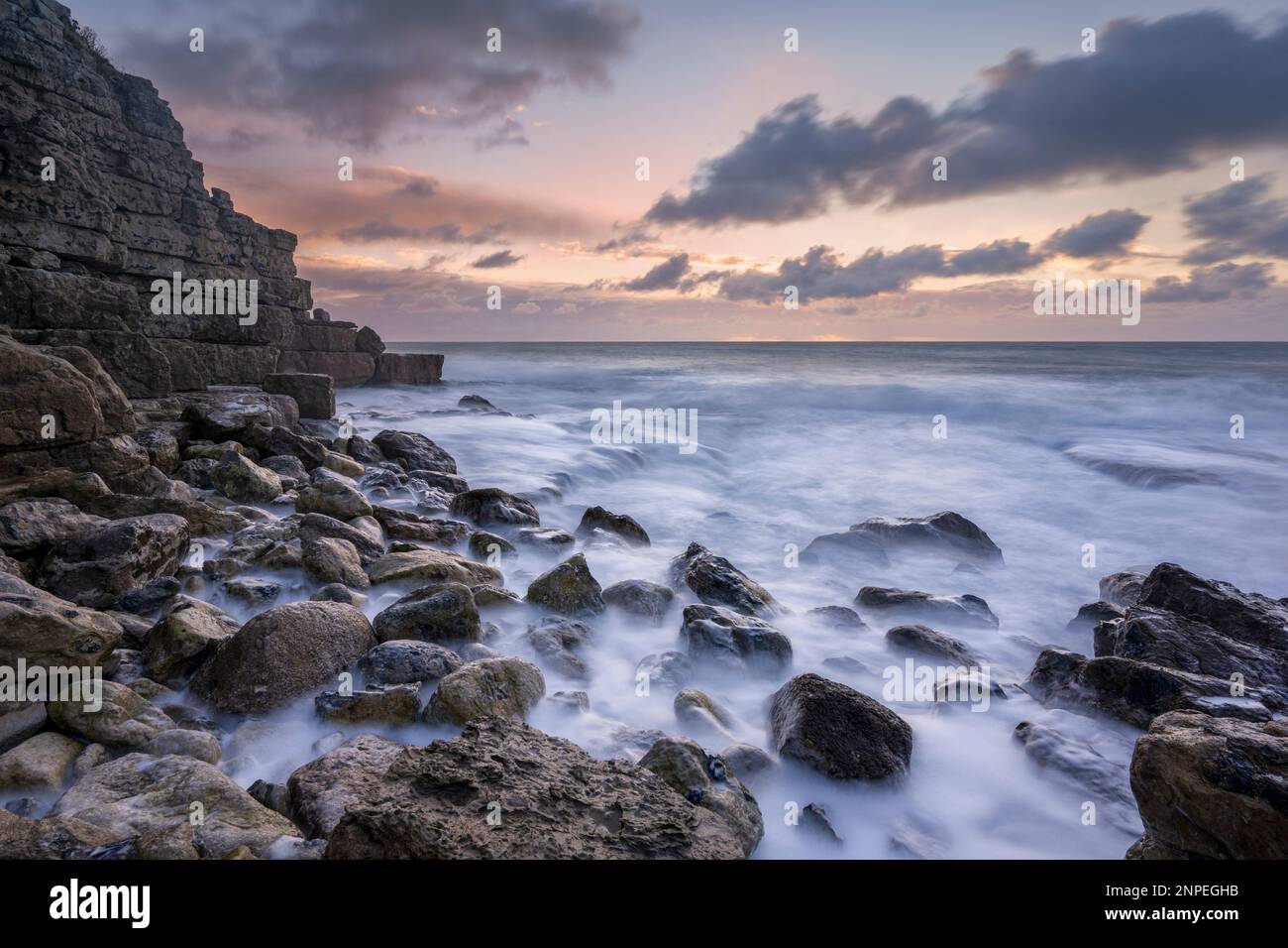 Onde che si lavano su rocce in primo piano a Winspit in Dorset. Foto Stock