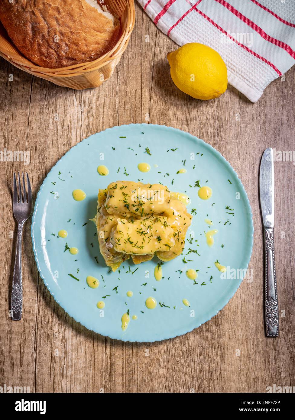 Tradizionali involtini di cavolo greco (Lahanodolmades) con carne macinata di manzo, riso e salsa di panna su un tavolo di legno Foto Stock