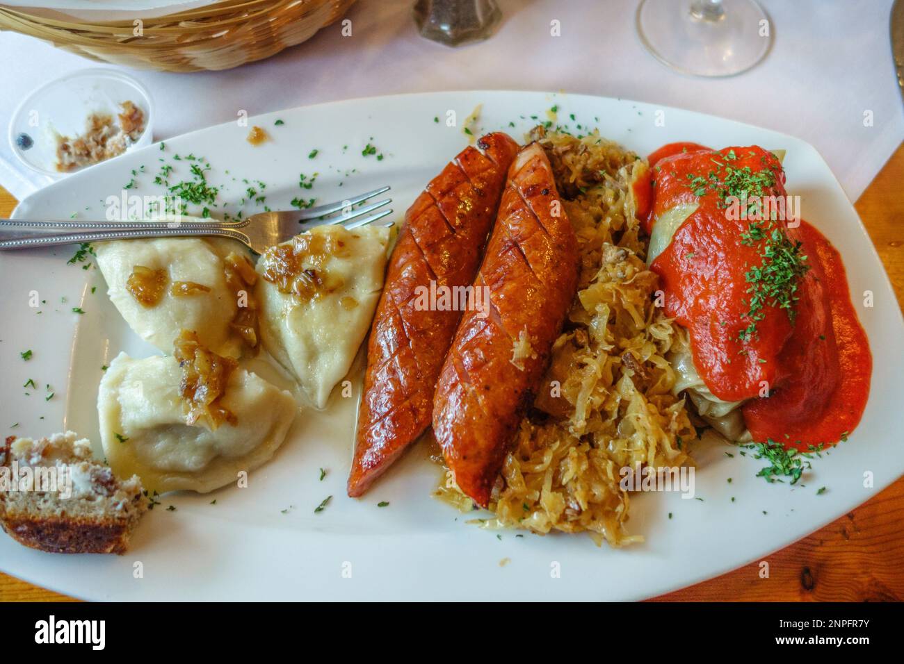 Pasto polacco su piatto con salsicce, pierogis, crauti e cavolo. Foto Stock