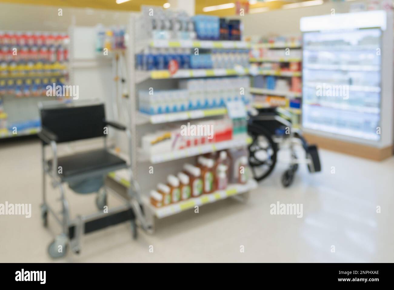 farmacia negozio interno con farmaci vitamine supplemento sedia a rotelle e prodotti sanitari per la salute su scaffali sfondo sfocato Foto Stock