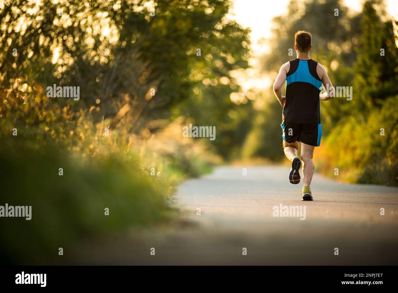 Scatto di un giovane atleta maschile allenamento. Ottenere la sua dose giornaliera di miglia, per rimanere in forma e magro. Foto Stock