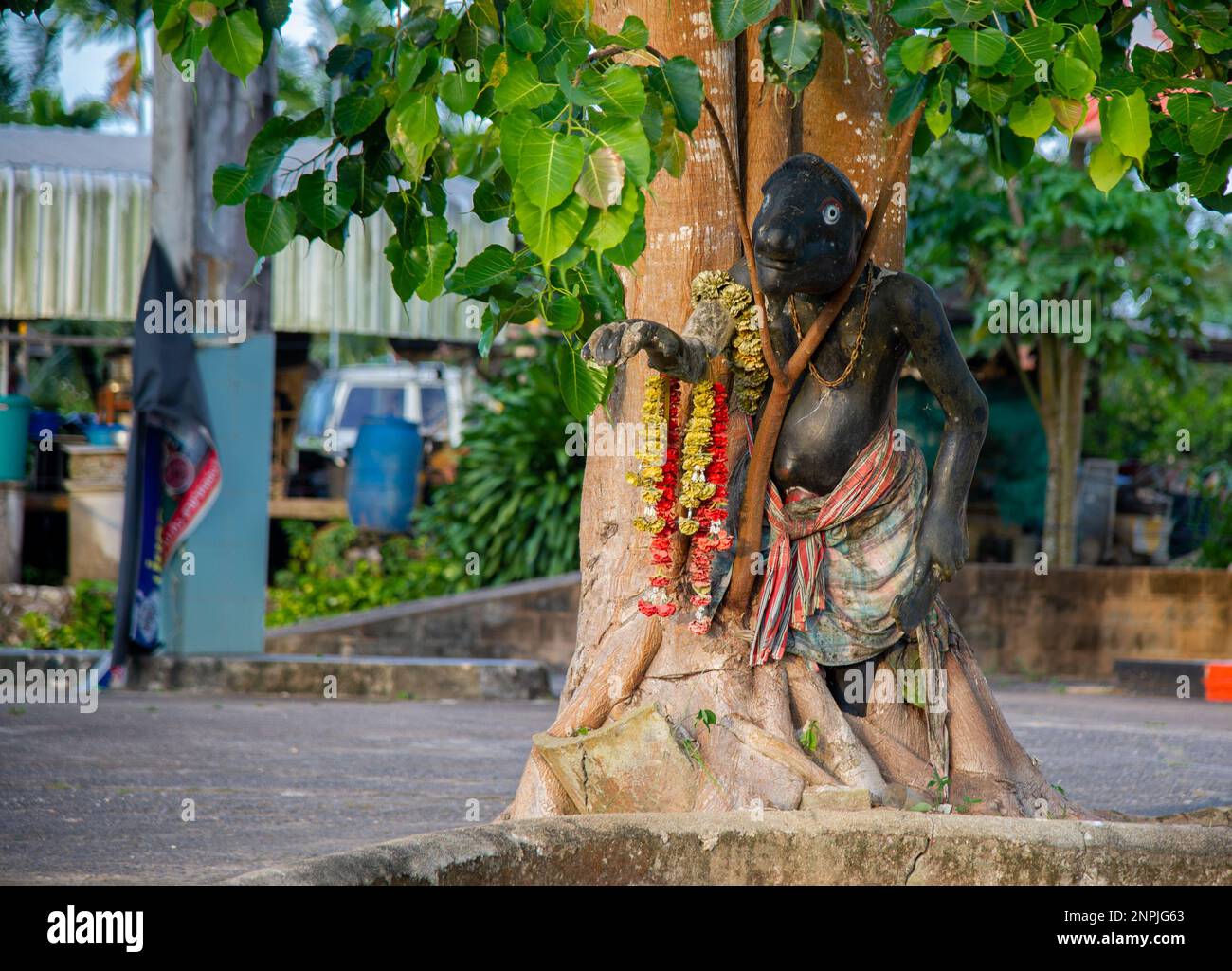 Statua strana e spaventosa accanto ad un albero in Thailandia. Raffigurante un comico del sud del paese Foto Stock