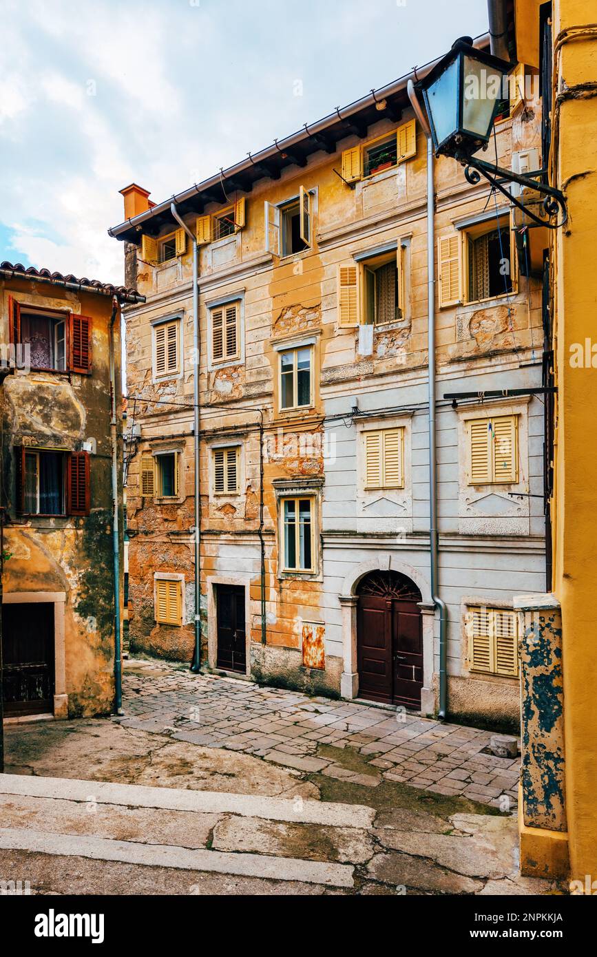 Centro storico di Lovran in Croazia, architettura istriana con facciate logore e persiane in legno, focalizzazione selettiva Foto Stock