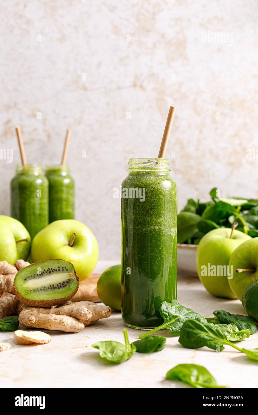 Frullato. Frullato di spinaci disintossicanti freschi e sani con mela verde, kiwi e zenzero in bottiglia su un tavolo. Dieta sana vegan cibo pieno di antioxid Foto Stock