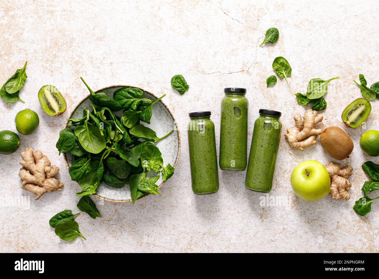 Frullato. Frullato di spinaci disintossicanti freschi e sani con mela verde, kiwi e zenzero in bottiglia su un tavolo. Dieta sana vegan cibo pieno di antioxid Foto Stock