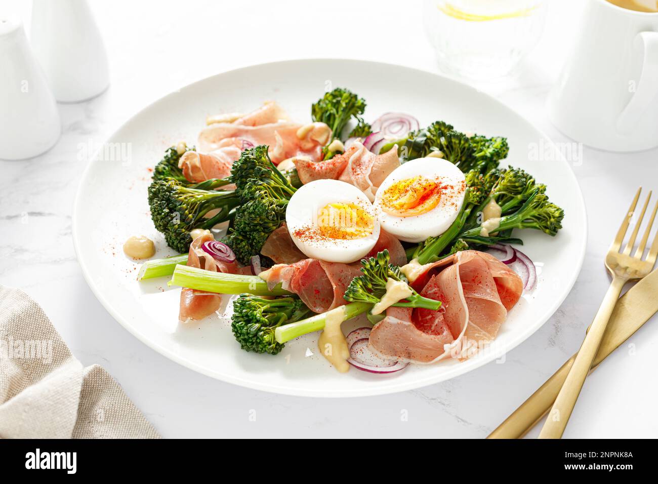 Insalata di uova di Pasqua con prosciutto e broccolini su fondo bianco. Insalata di Pasqua con uova sode Foto Stock