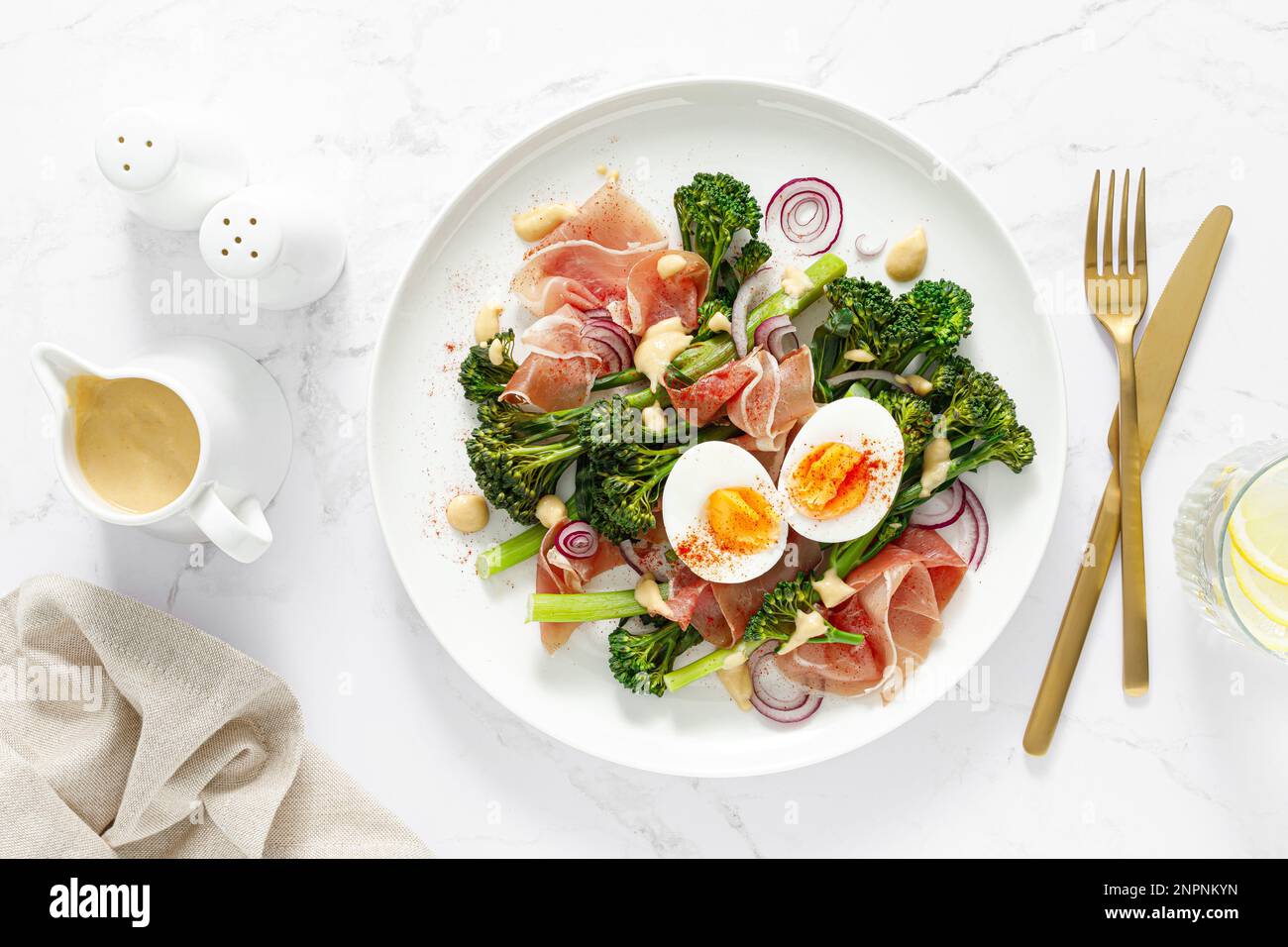 Insalata di uova di Pasqua con prosciutto e broccolini su sfondo bianco, vista dall'alto. Insalata di Pasqua con uova sode Foto Stock