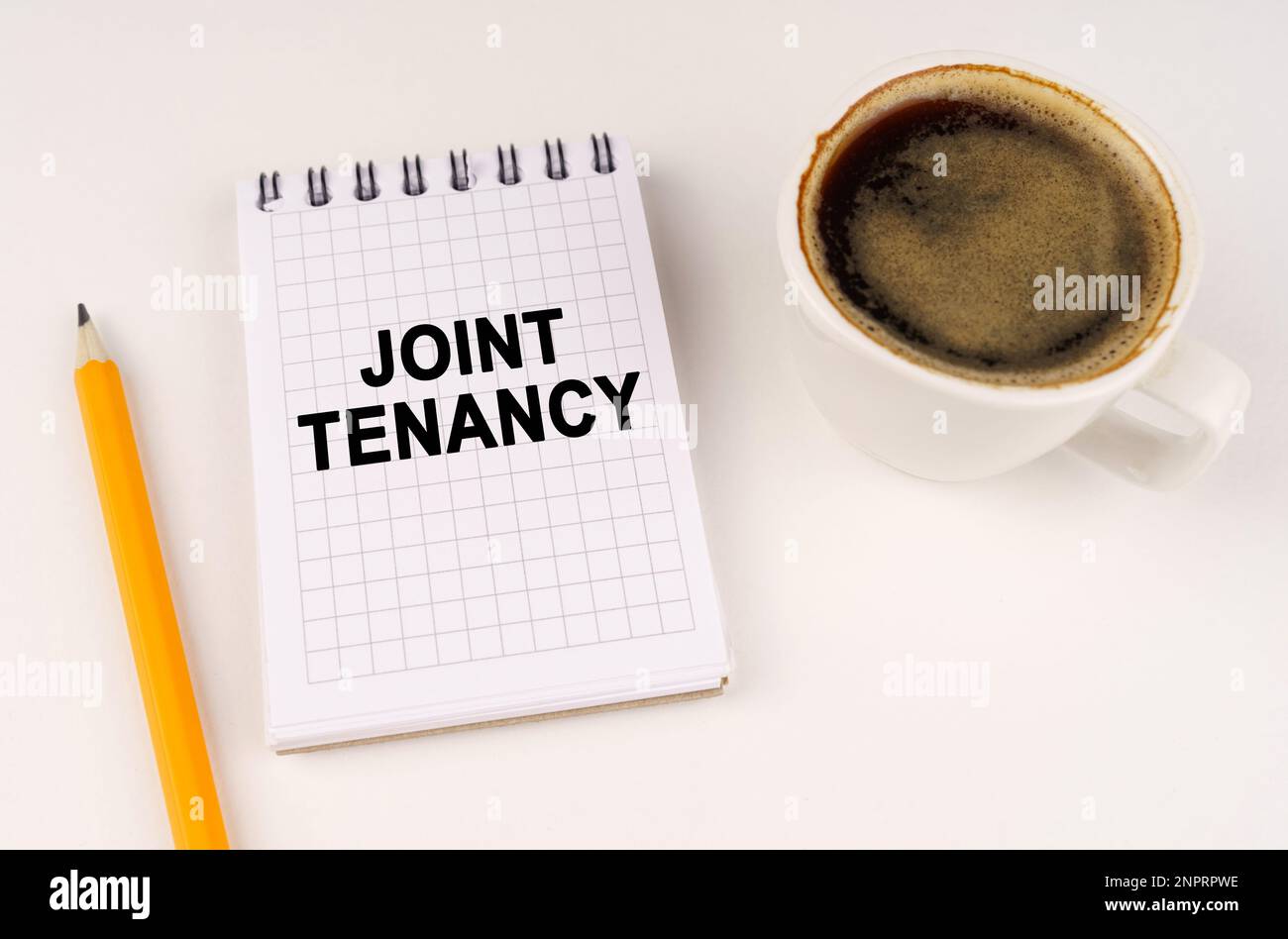 Concetto aziendale. Su una superficie bianca, una tazza di caffè, una matita e un blocco note con l'iscrizione - LOCAZIONE CONGIUNTA Foto Stock