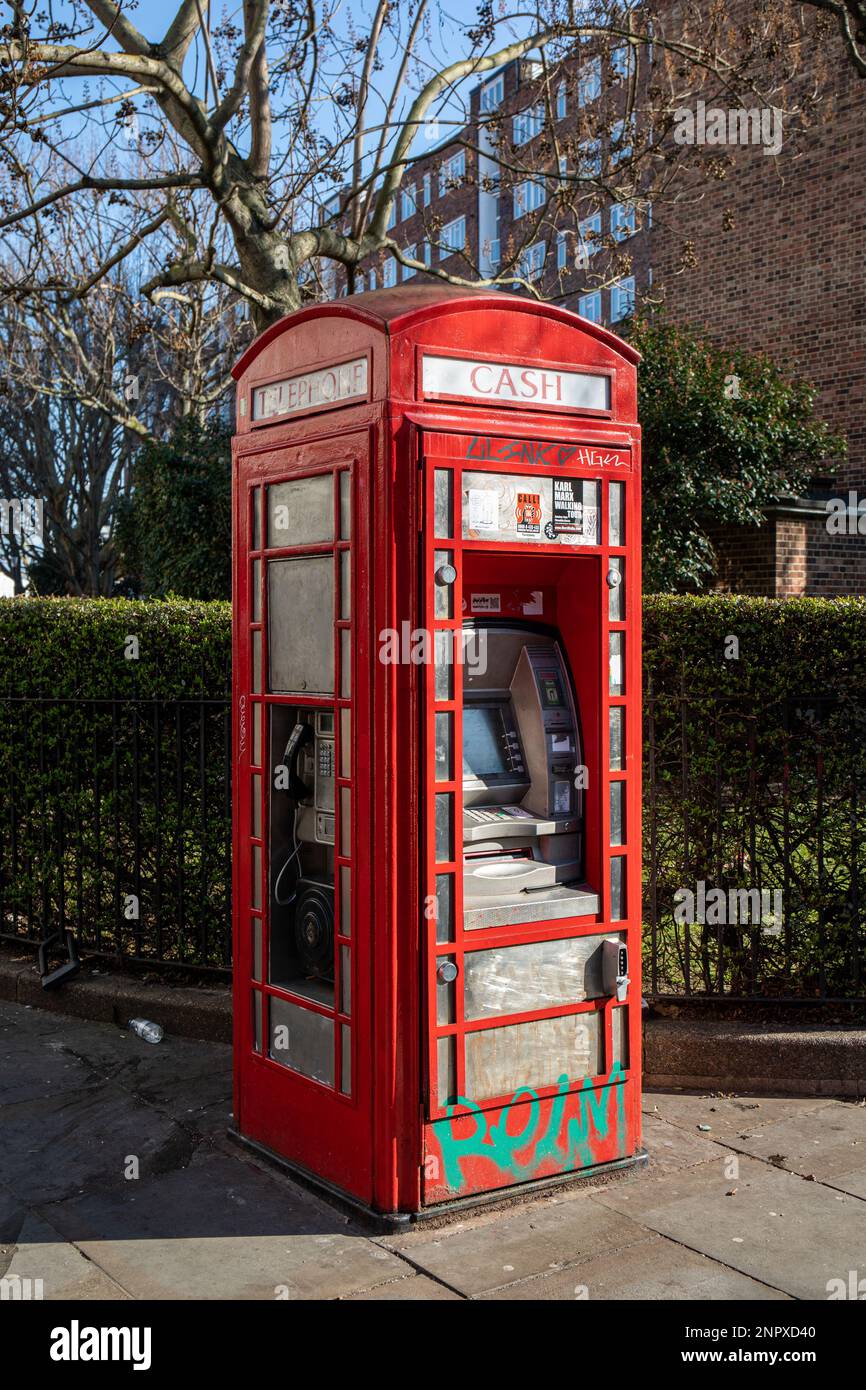 Vecchia cabina telefonica tradizionale convertita in un cashpoint o un bancomat e moderno telefono a pagamento su Portobello Road di Notting Hill, Londra, Inghilterra Foto Stock