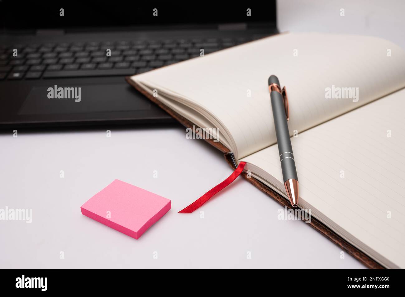 Un notebook aperto con un computer portatile e una penna su un desktop che  si adatta a un ufficio domestico o a una scrittura creativa Foto stock -  Alamy