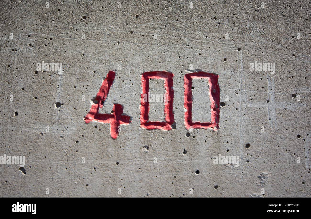 il numero 400 scolpito in un muro di cemento in rosso Foto Stock