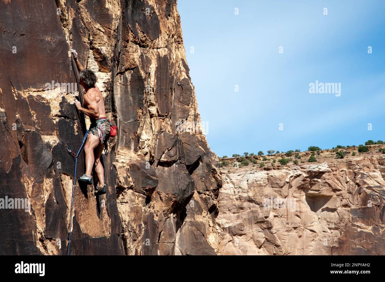 Arrampicata maschile su roccia per adulti nel deserto centrale dello Utah. STATI UNITI Foto Stock