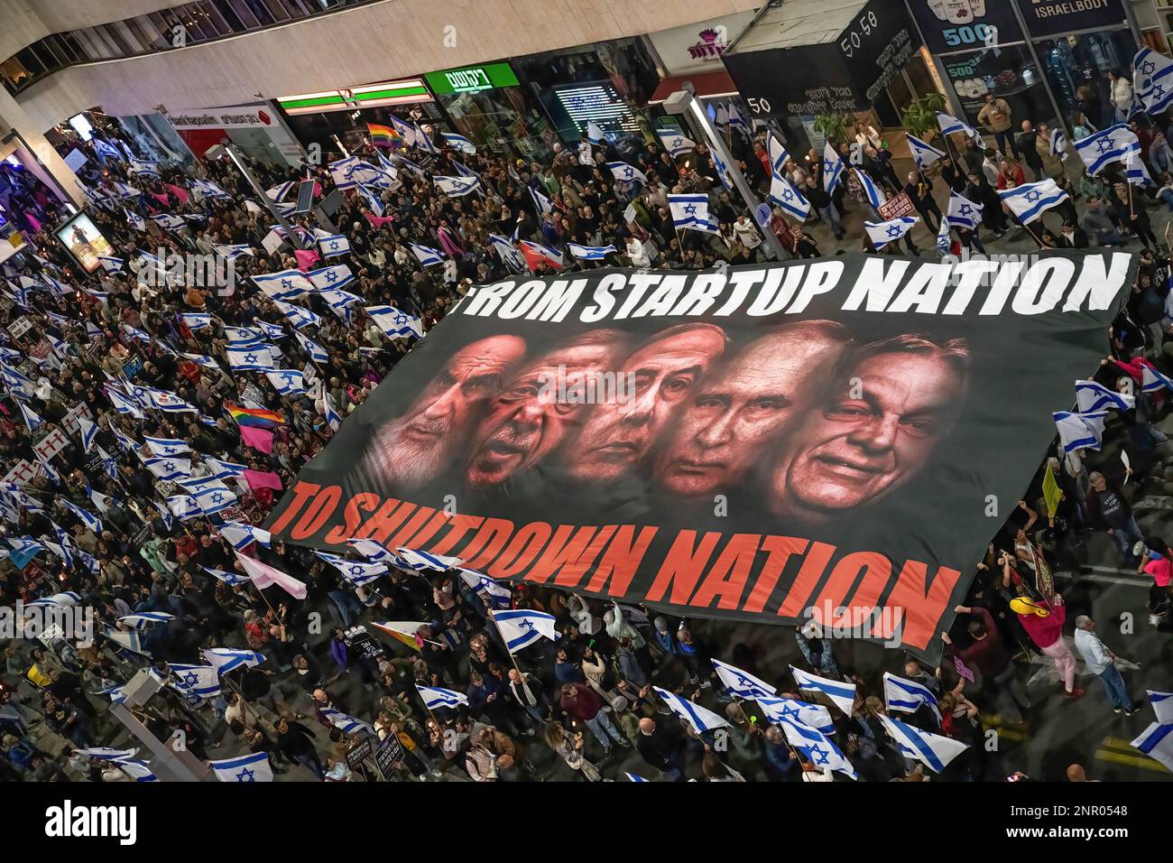 Tel Aviv, Israele. 25th Feb, 2023. I manifestanti che detengono bandiere israeliane portano una bandiera gigante con le immagini di Ruhollah Khomeini, Recep Tayyip Erdo?an, Benjamin Netanyahu, Vladimir Putin e Viktor Orbán durante una protesta contro la revisione giudiziaria. Oltre 150.000 persone hanno protestato a Tel Aviv contro il governo di estrema destra di Netanyahu e la sua controversa riforma legale. 21 dimostranti sono stati arrestati mentre bloccavano l'autostrada Ayalon. Credit: SOPA Images Limited/Alamy Live News Foto Stock