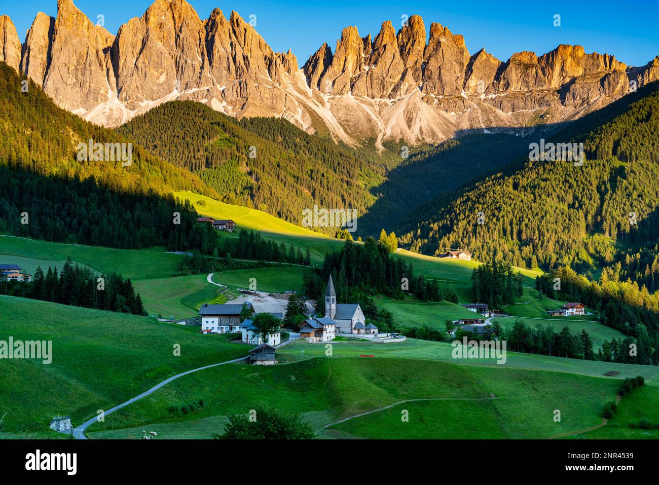 Luce serale in Val di Funes o Val di Funes con il picco delle Odle nelle Dolomiti italiane e la famosa Chiesa di S. Magdalena in Alto Adige, Italia Foto Stock