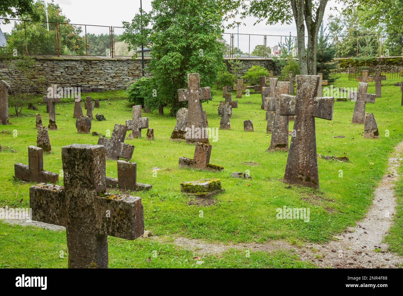 La crescita di muschio e lichene vecchia ha coperto le croci di pietra sulla cima di tombe in cimitero presso le rovine gotiche del monastero di Pirita dedicato a St Bridget, Tallinn. Foto Stock