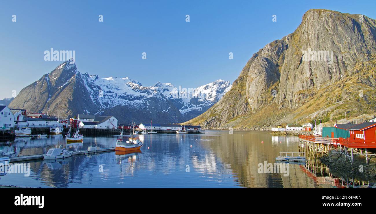 Rorbuer e barche da pesca, alta montagna riflessa in un fiordo, idil invernale, Hamnöy, Reinefjorden, Lofoten, Norvegia, Europa Foto Stock