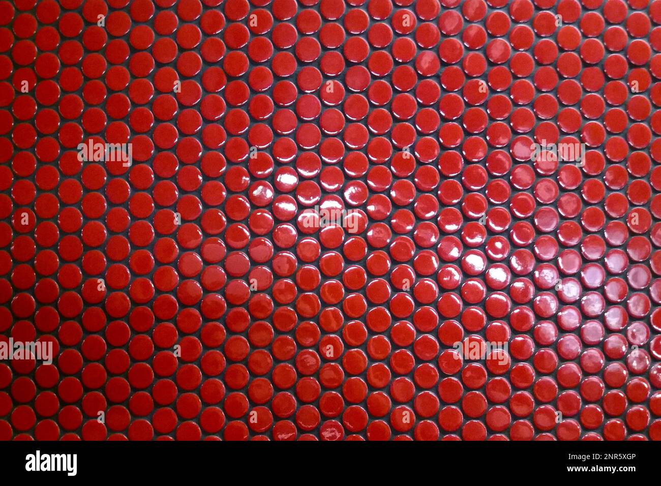 Primo piano sulle piastrelle circolari rosse della metropolitana di Parigi. Foto Stock